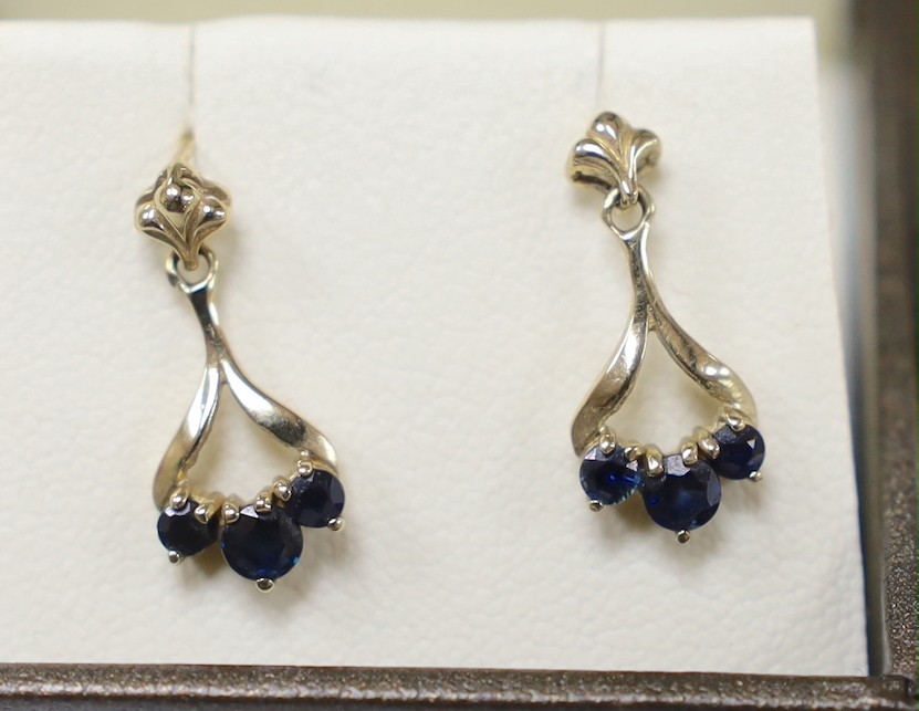 Three assorted modern pairs of yellow metal earrings, including tassel drop, 9ct gold and three stone sapphire (lacking butterflies) and 375 garnet and diamond chip